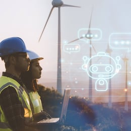 Zwei Fachkräfte im Energiesektor beobachten Windturbinen, während ein KI-basierter Assistent auf ihrem Laptop eingeblendet wird, der mit ihnen interagiert.